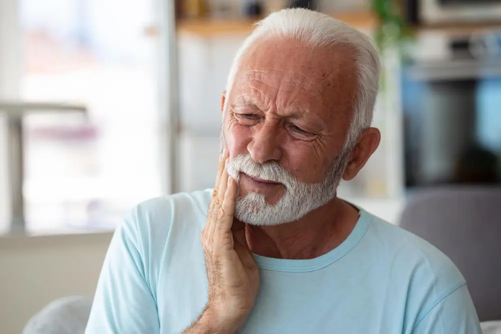 Older man holding jaw in pain needing Eugene, TMJ Treatment.